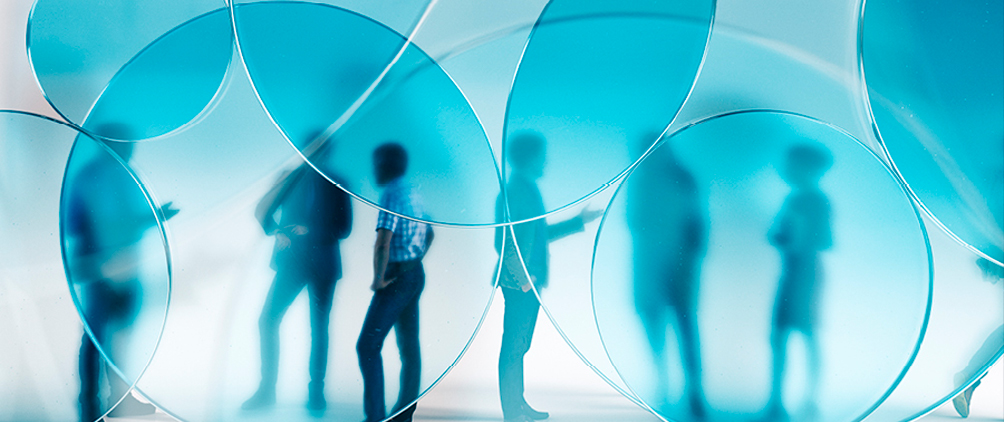 Blue-tinted abstract image of people behind circular glass shapes representing Adams Street Partners’ discussion of BDC and interval fund redemptions, transparency and private credit manager quality.
